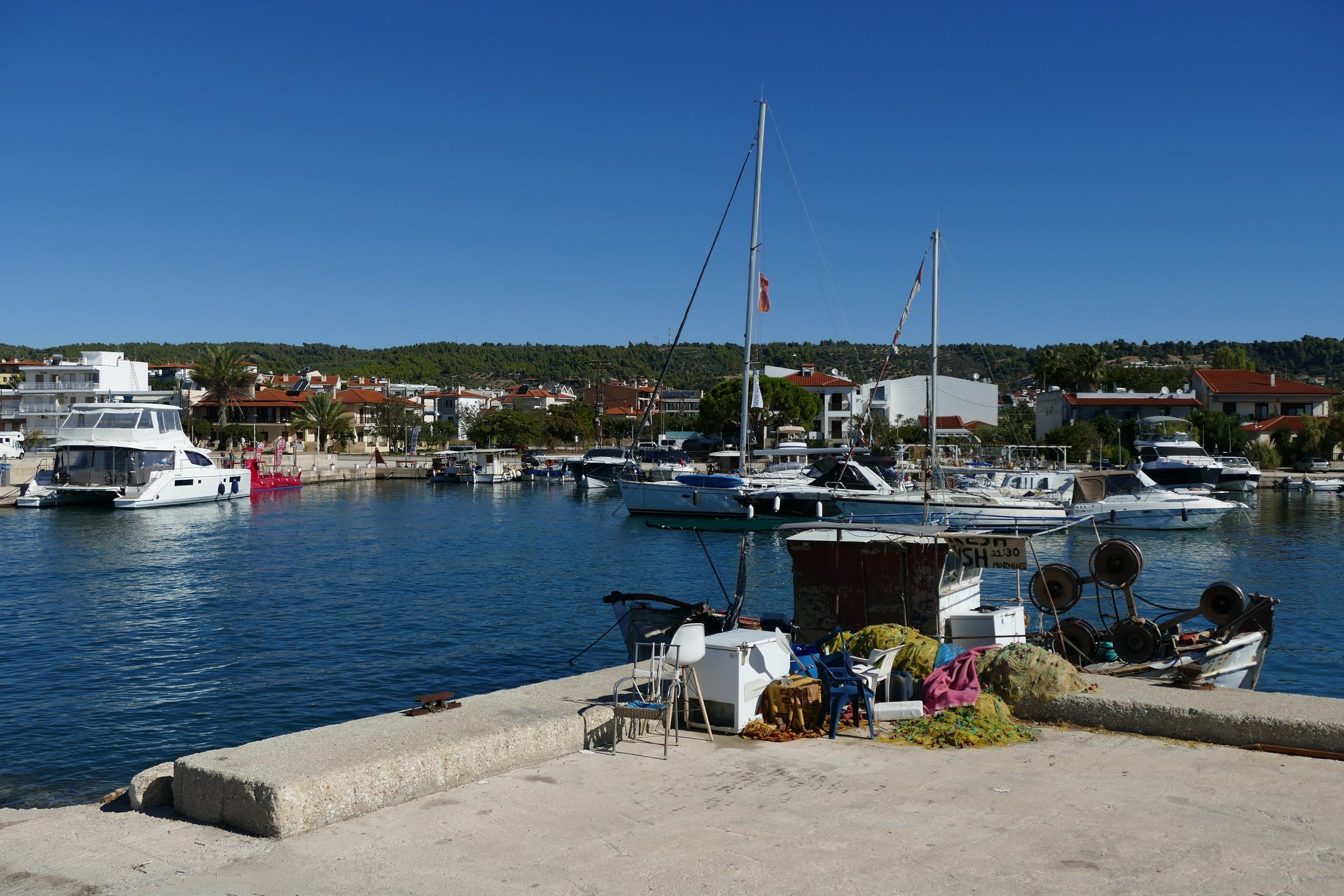 Fishing boat, nets and sailing yachts in Nikiti harbour