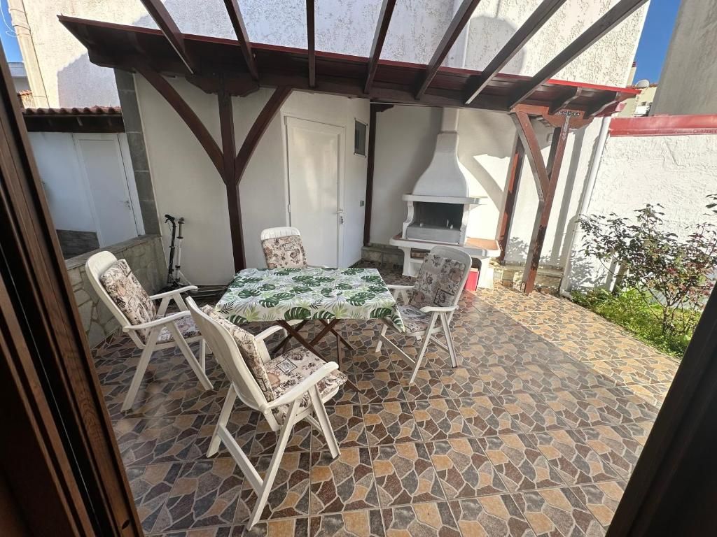 Covered barbecue patio at Villa Anastassia with an outdoor dining table and chairs