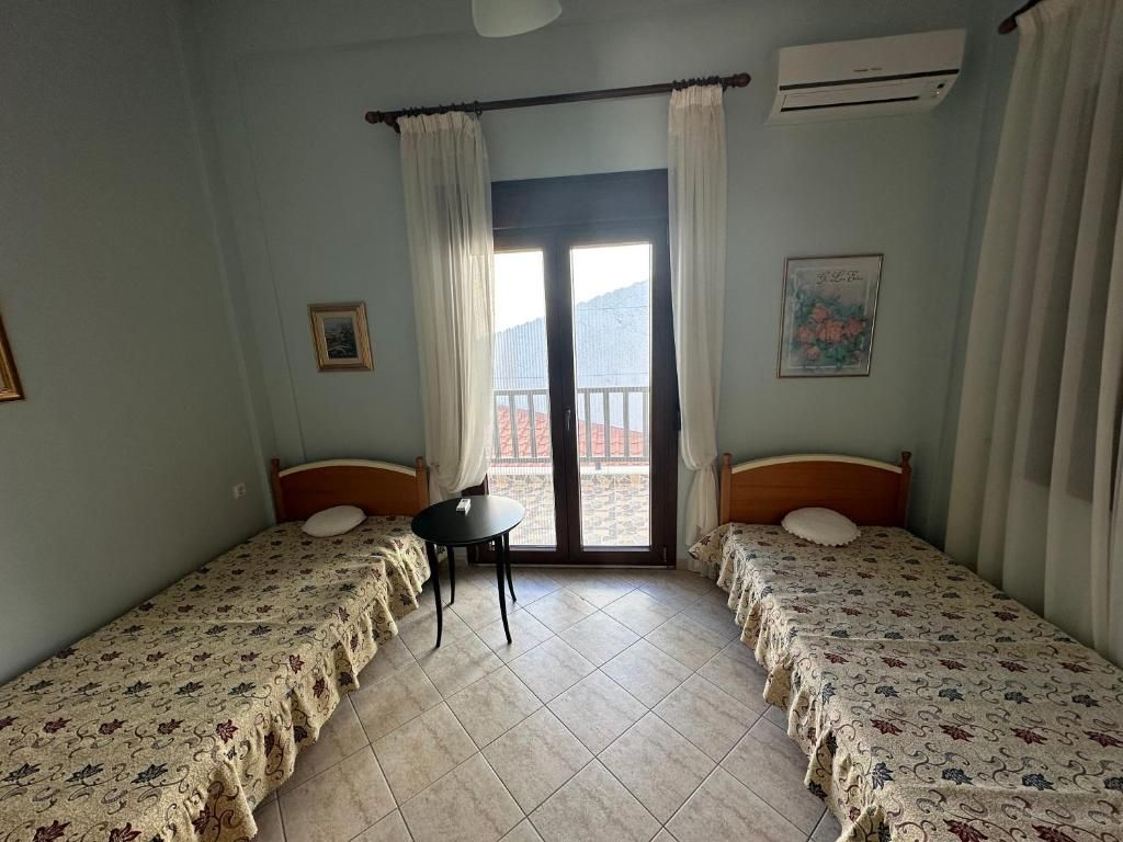 Bedroom with two twin beds and a balcony door at Villa Anastassia