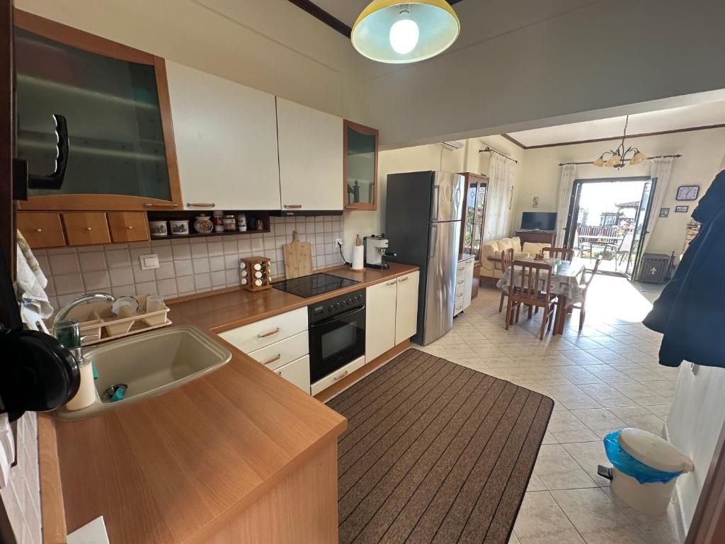 Fully equipped kitchen at Villa Anastassia with oven, cooktop, sink, refrigerator and dining area