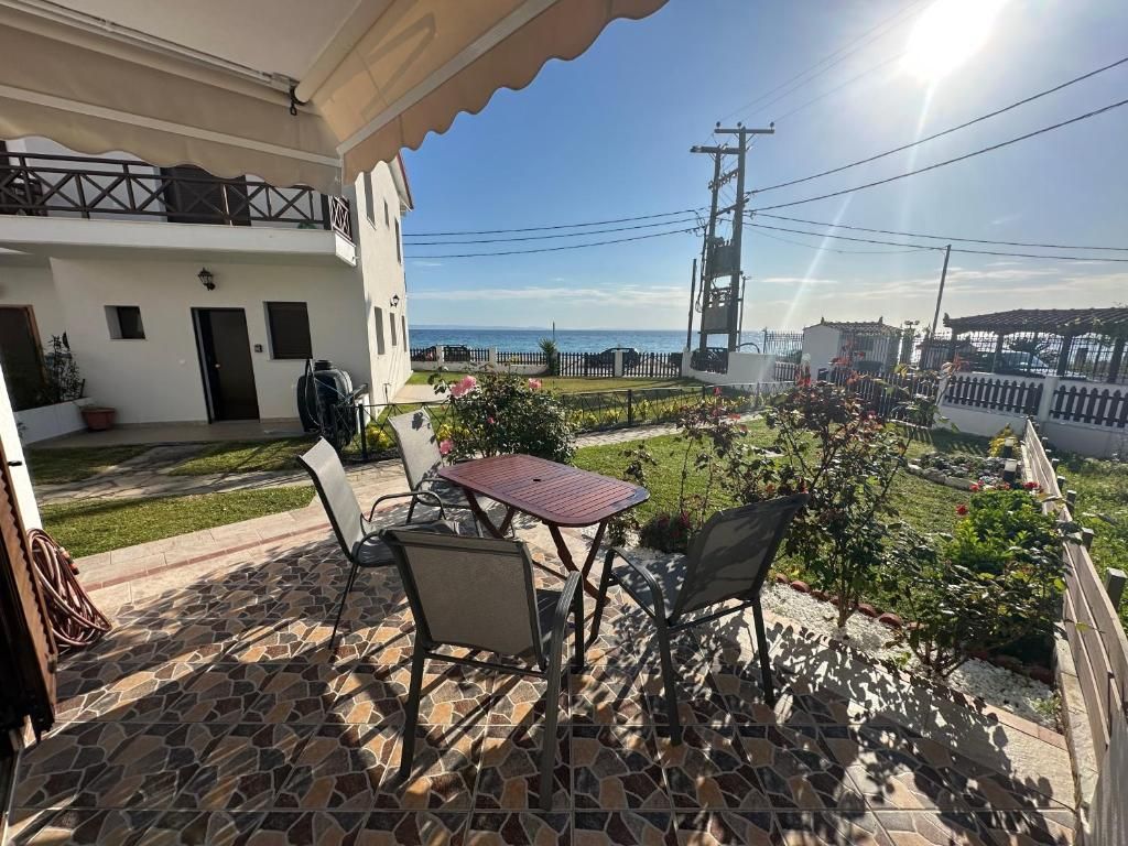 Sunny sea-view veranda at Villa Anastassia with an outdoor table and chairs